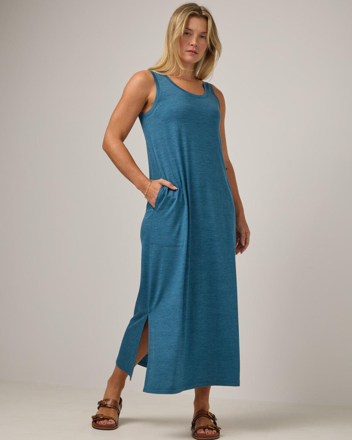 Model wearing Audrey TENCEL™ Maxi Dress in Ocean Teal Heather, a medium blue-green color. Audrey TENCEL™ Maxi Dress is a merino wool sleeveless, scoop neck, maxi shift dress with pockets available in sizes XS-3X.