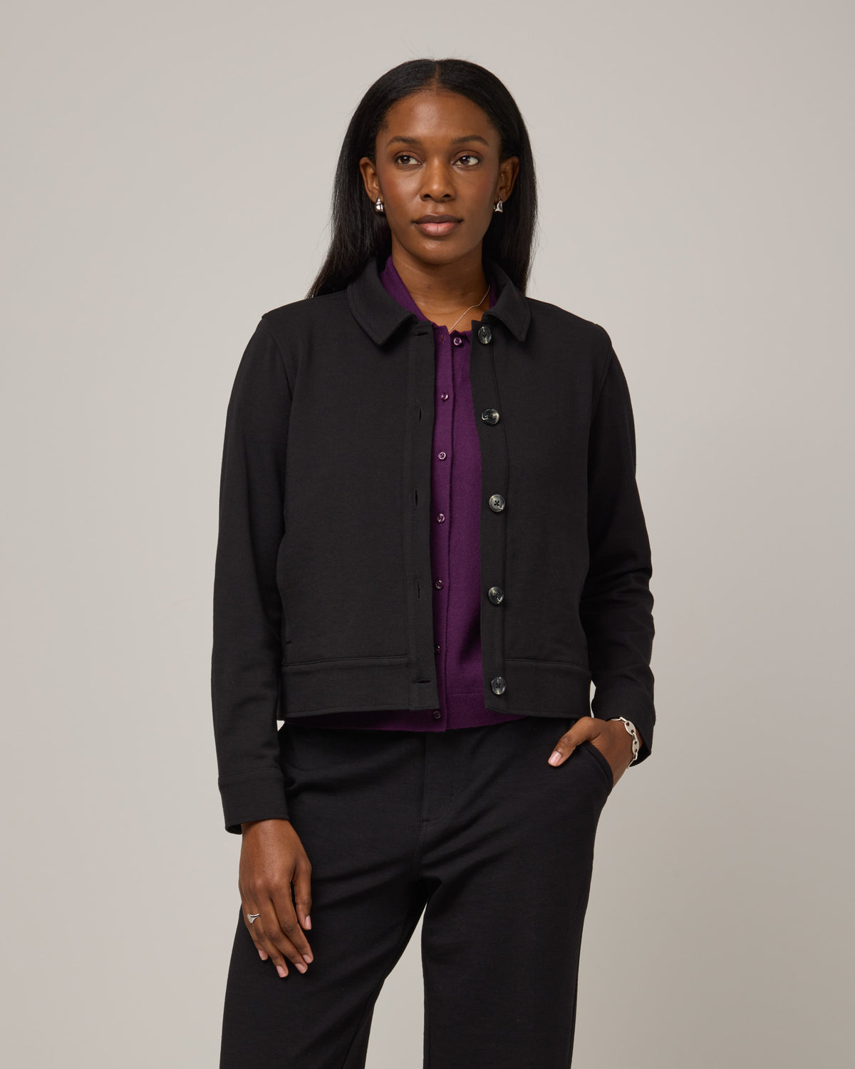 Model wearing Johnny Ponte Jacket in Black. Johnny Ponte Jacket is a merino wool long sleeve, collared, jacket with pockets available in sizes XS-XXL.