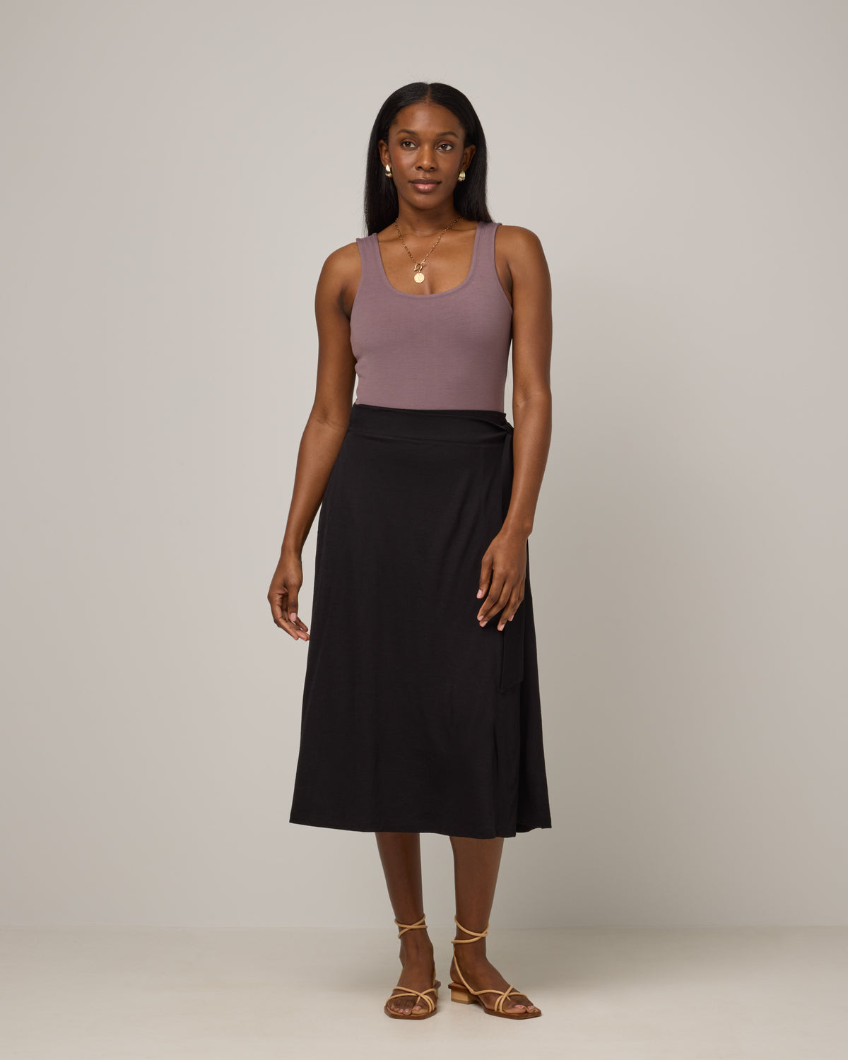 Model wearing Skye Wrap Skirt in Black. Skye Wrap Skirt is a merino wool midi length skirt with pockets available in sizes XS-3X.