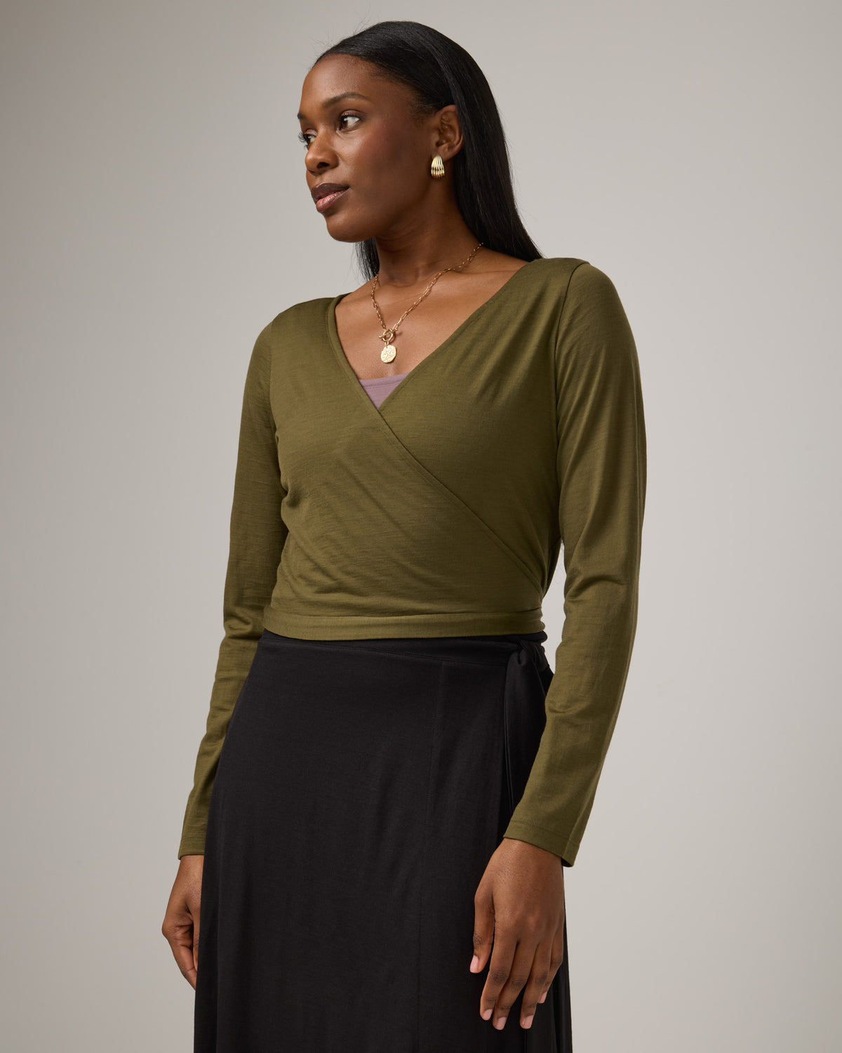 Model wearing Natalia Wrap Top in Olive. Natalia Wrap Top is a merino wool long sleeve, v-neck, slim fit top available in sizes XS-3X.