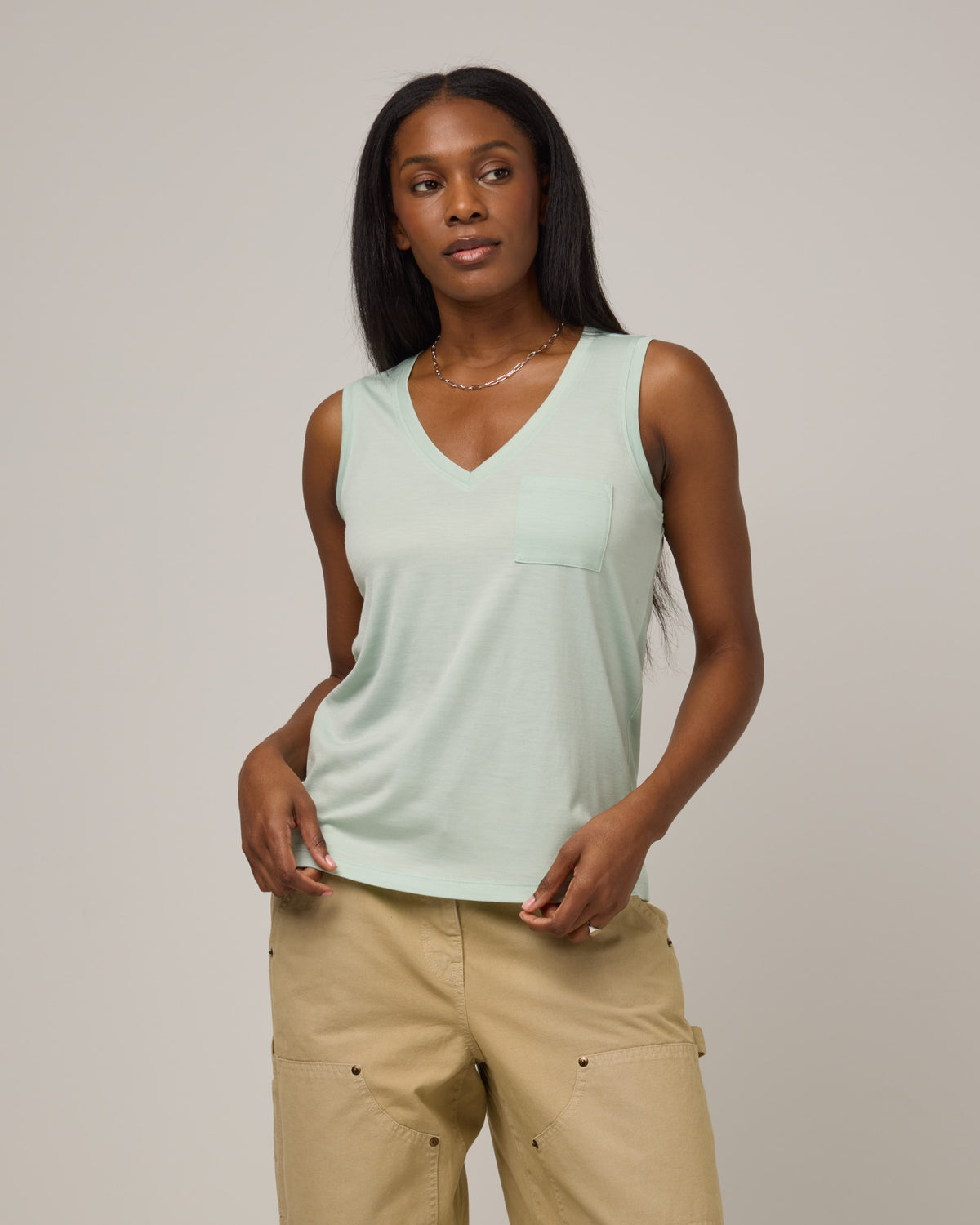 Model wearing Penelope Pocket Tank in Morning Dew, a light mint green color. Penelope Pocket Tank is a merino wool sleeveless, v-neck tank with a pocket available in sizes XS-3X.