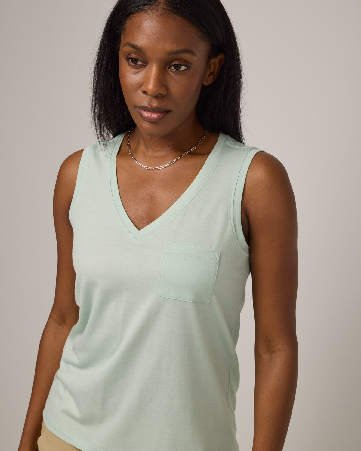 Model wearing Penelope Pocket Tank in Morning Dew, a light mint green color. Penelope Pocket Tank is a merino wool sleeveless, v-neck tank with a pocket available in sizes XS-3X.