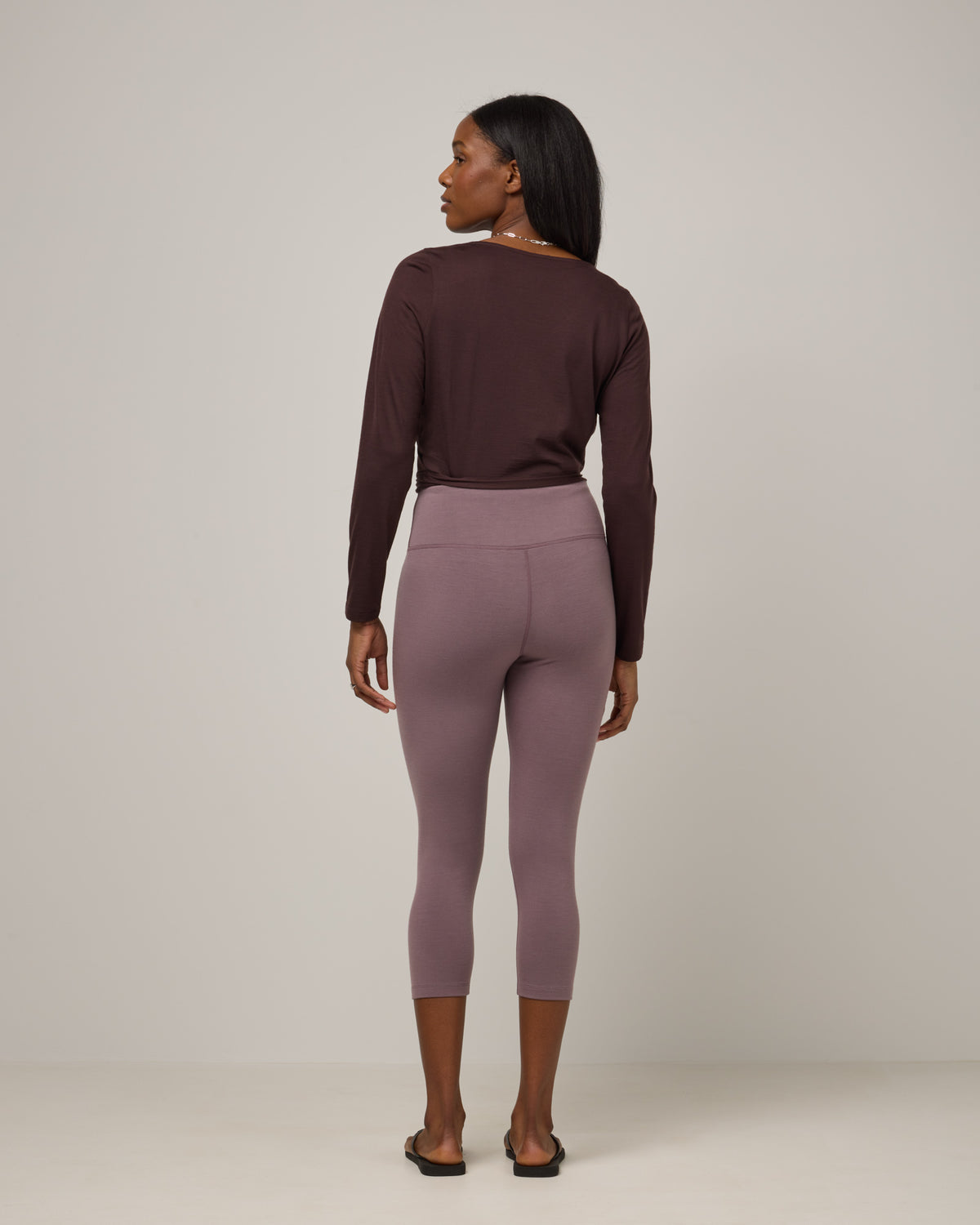 Model wearing Summit Crop Legging in Lavender, a dusky muted purple color. Summit Crop Legging is a merino wool legging available in sizes XS-3X.