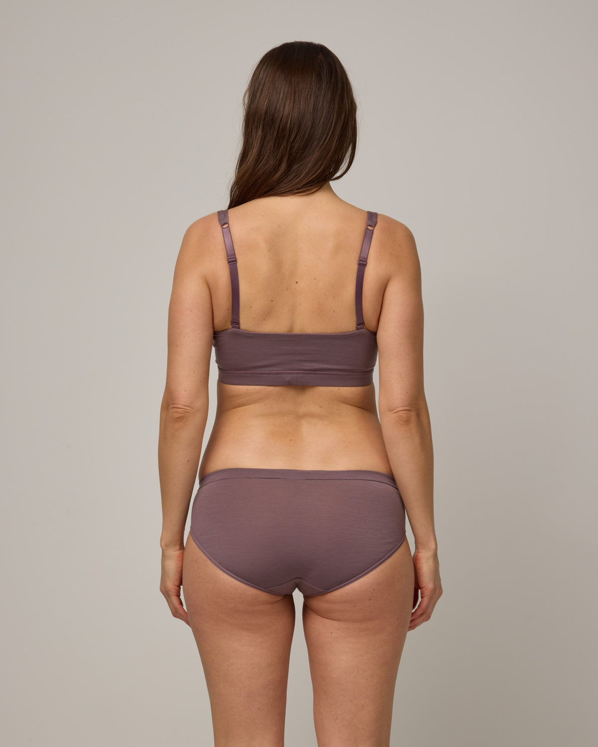 Model wearing Roam Convertible Wrap Bra and Roam Bikini underwear set in Lavender, a dusky, muted purple color. 