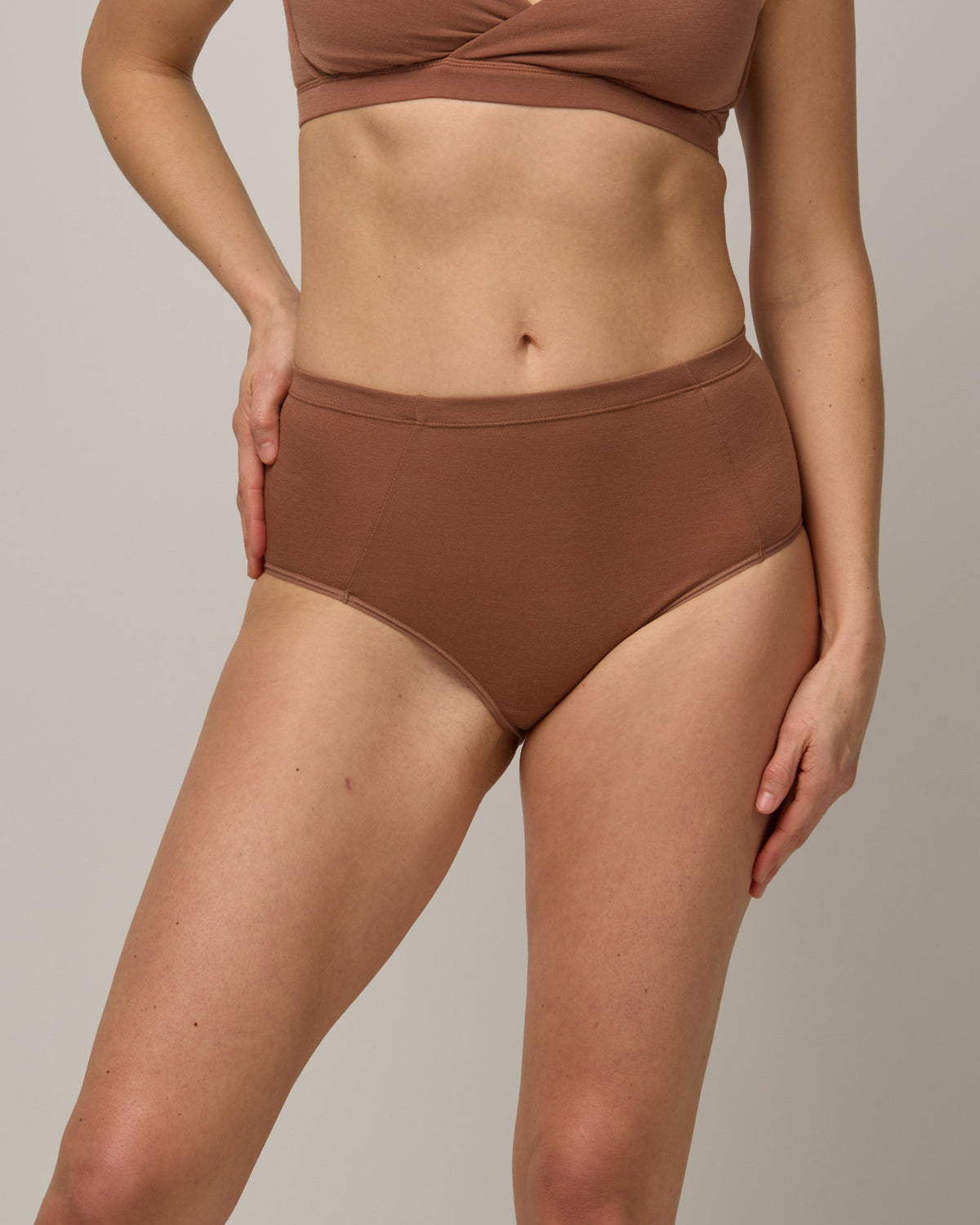Model wearing Roam High Waist Bikini in Mocha Brown, a medium-dark nude color. Roam High Waist Bikini is a merino wool underwear available in sizes XS-3X.
