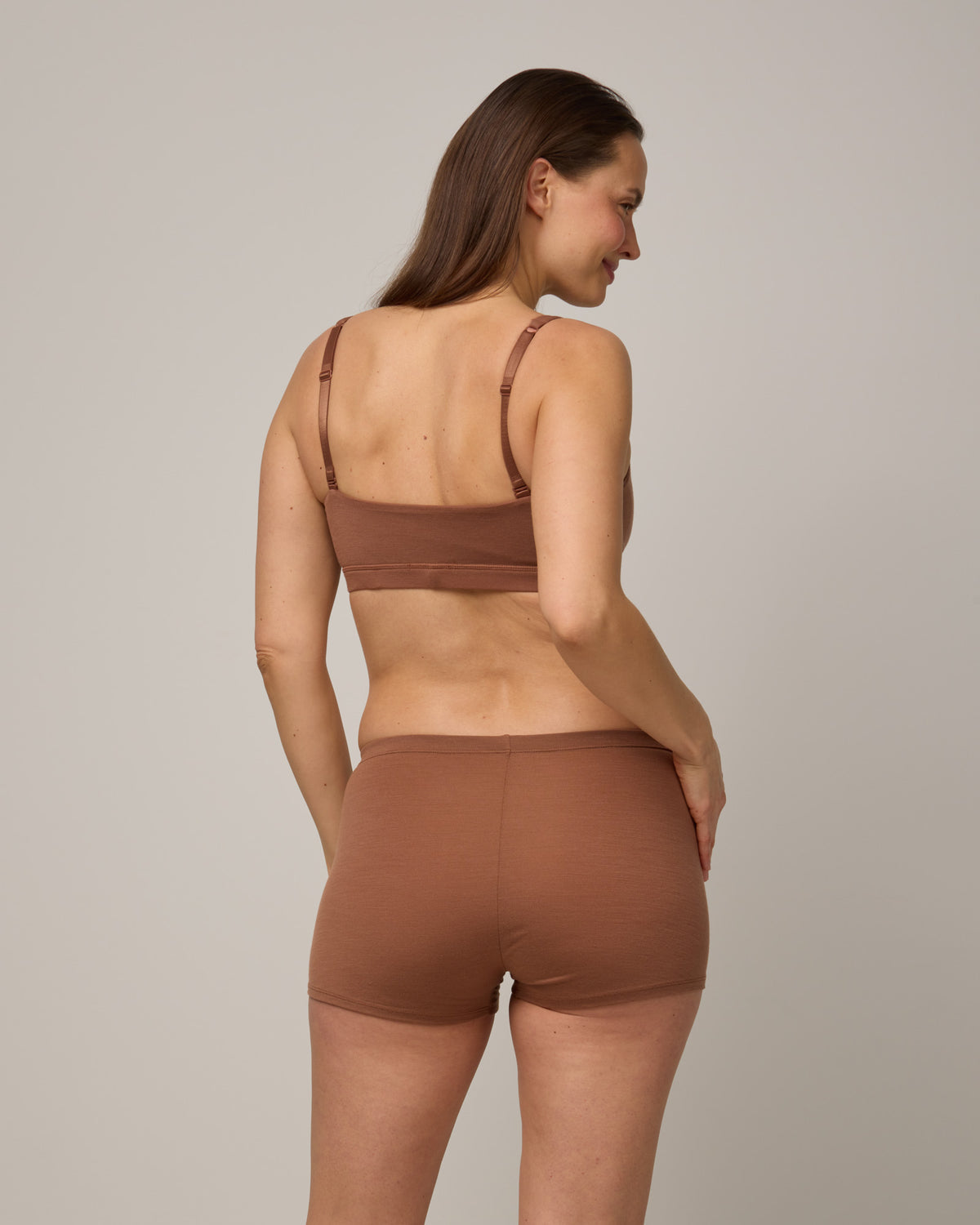 Model wearing Roam High Waist Shortie in Mocha Brown, a medium-dark nude color. Roam High Waist Shortie is a merino wool underwear available in sizes XS-3X.