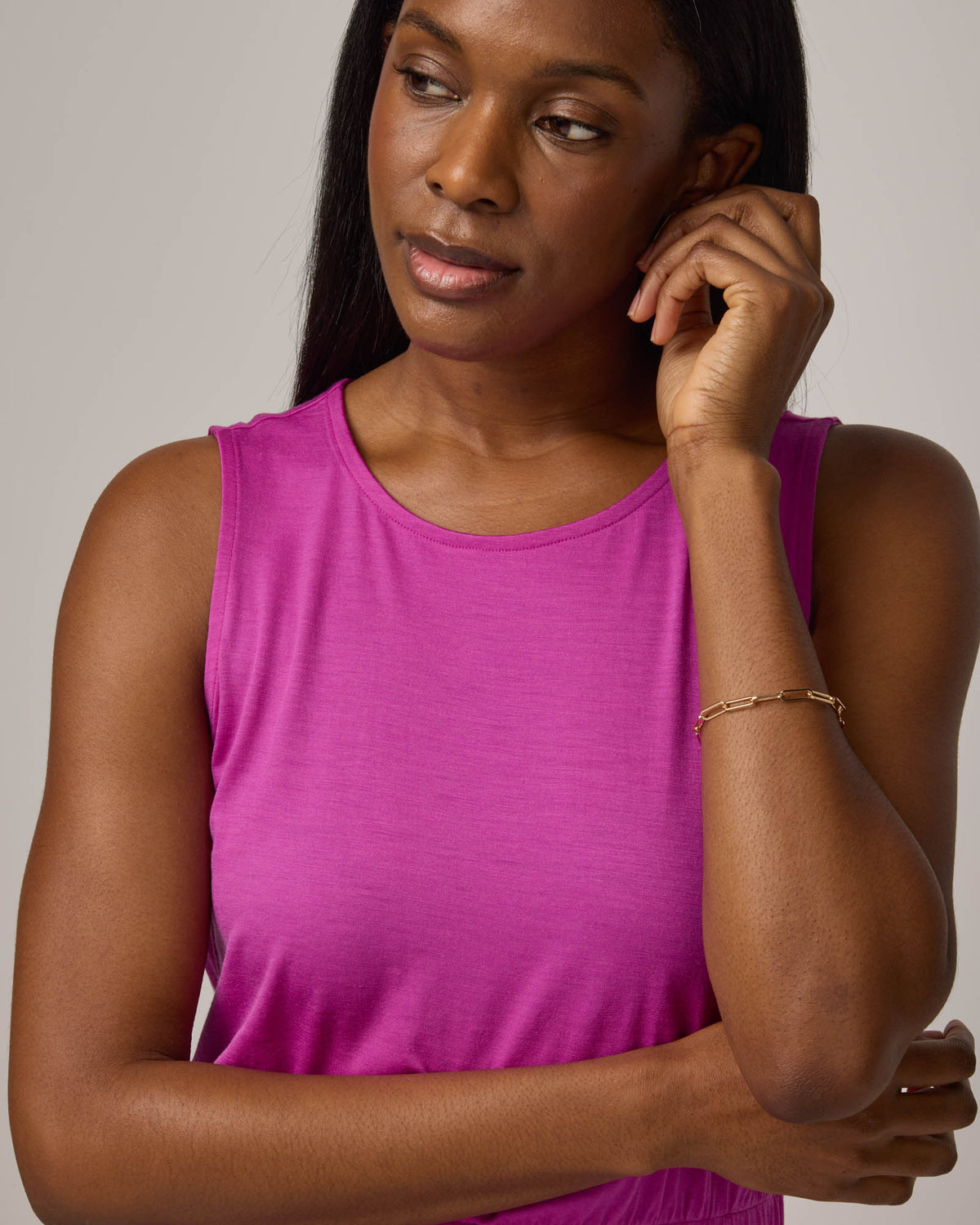 Model wearing Sofia Fit & Flare Dress in Petunia, a bright fuchsia pink-purple color. Sofia Fit & Flare Dress is a merino wool sleeveless, crew neck, midi fit & flare dress with pockets available in sizes XS-XXL.