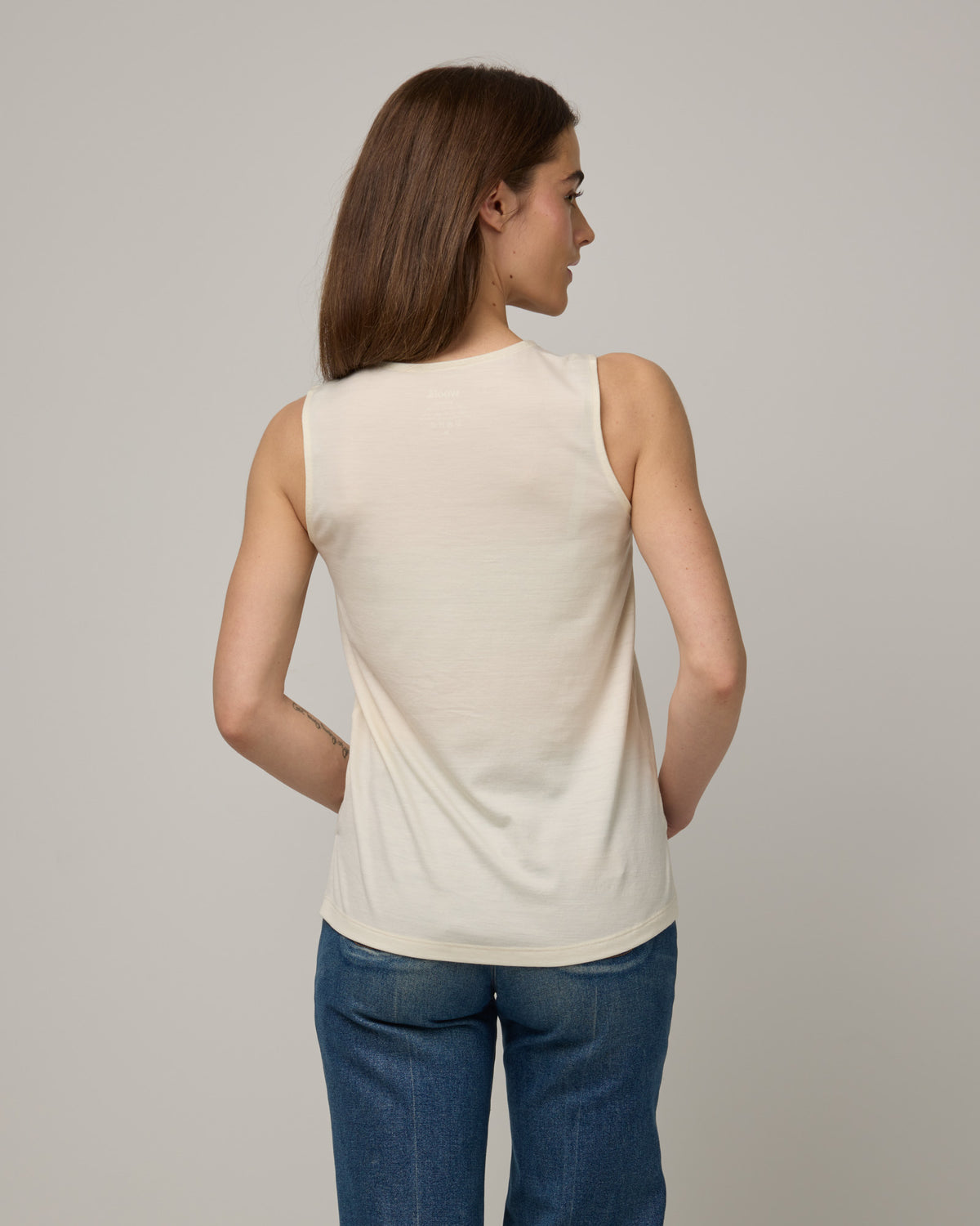 Model wearing Steph Scoop Neck Tank in Natural White. Steph Scoop Neck Tank is a merino wool sleeveless tank available in sizes XS-3X.  