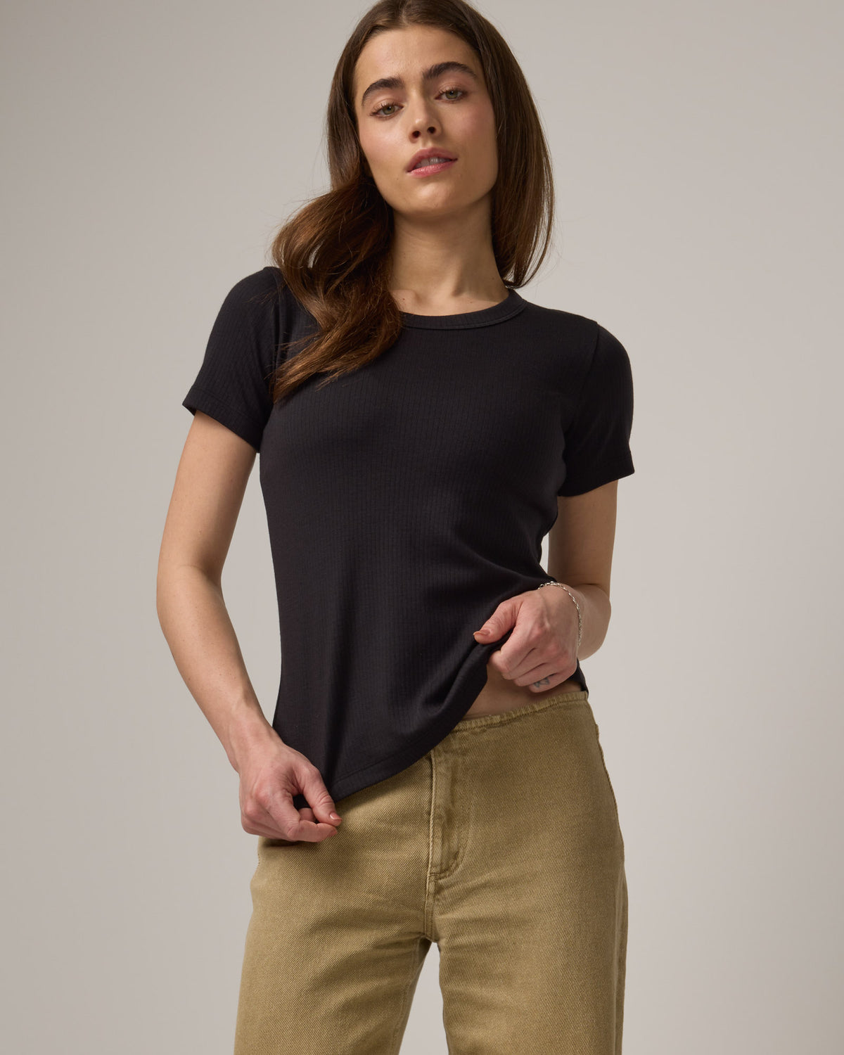 Model wearing Taylor Ribbed Tee in Black. Taylor Ribbed Tee is a merino wool short sleeve, crew neck tee available in sizes XS-3X. 