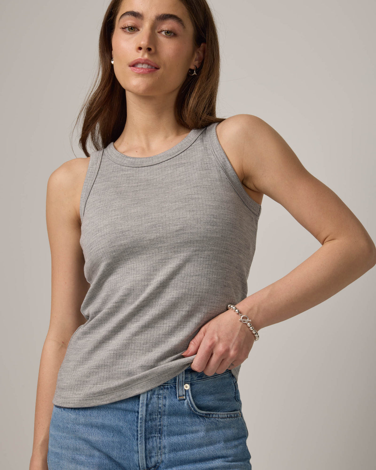 Model wearing Lily Ribbed Tee in Gray Heather. Lily Ribbed Tee is a merino wool sleeveless, crew neck tank available in sizes XS-3X. 