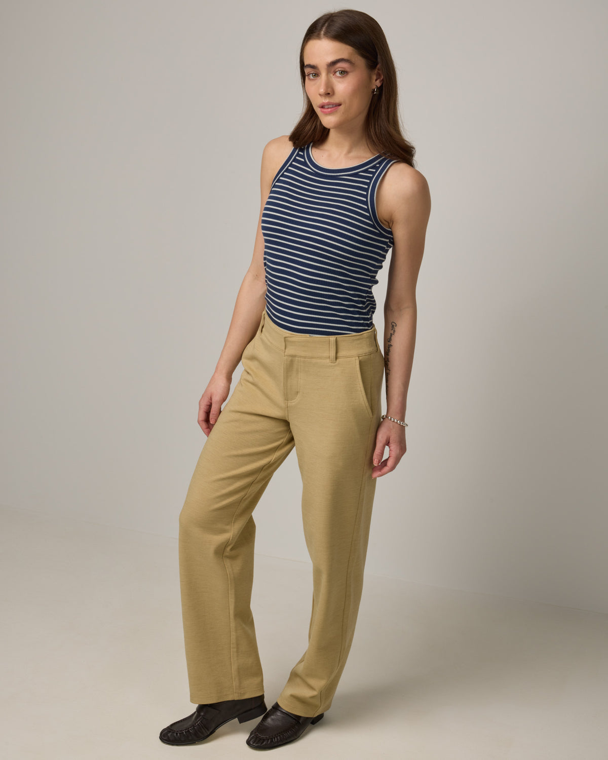 Model wearing Lily Ribbed Tee in Marine Blue & Natural White Stripe. Lily Ribbed Tee is a merino wool sleeveless, crew neck tank available in sizes XS-3X. 