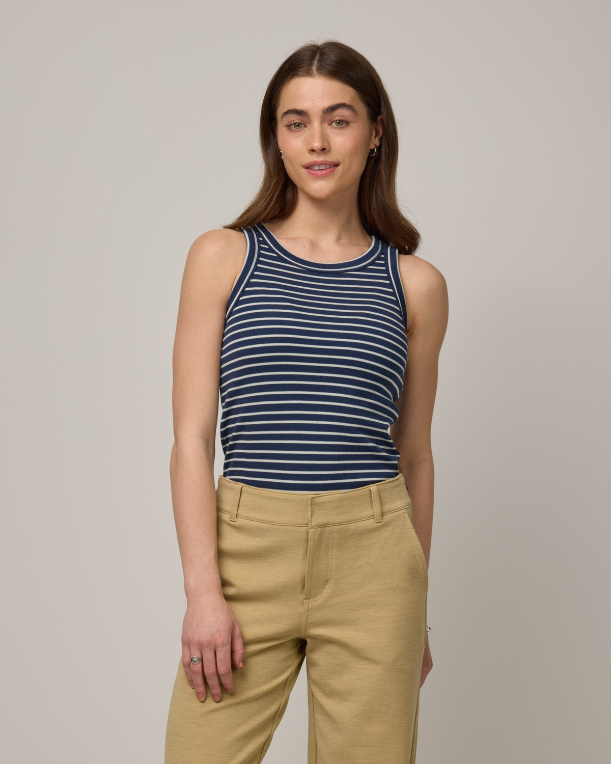 Model wearing Lily Ribbed Tee in Marine Blue & Natural White Stripe. Lily Ribbed Tee is a merino wool sleeveless, crew neck tank available in sizes XS-3X. 