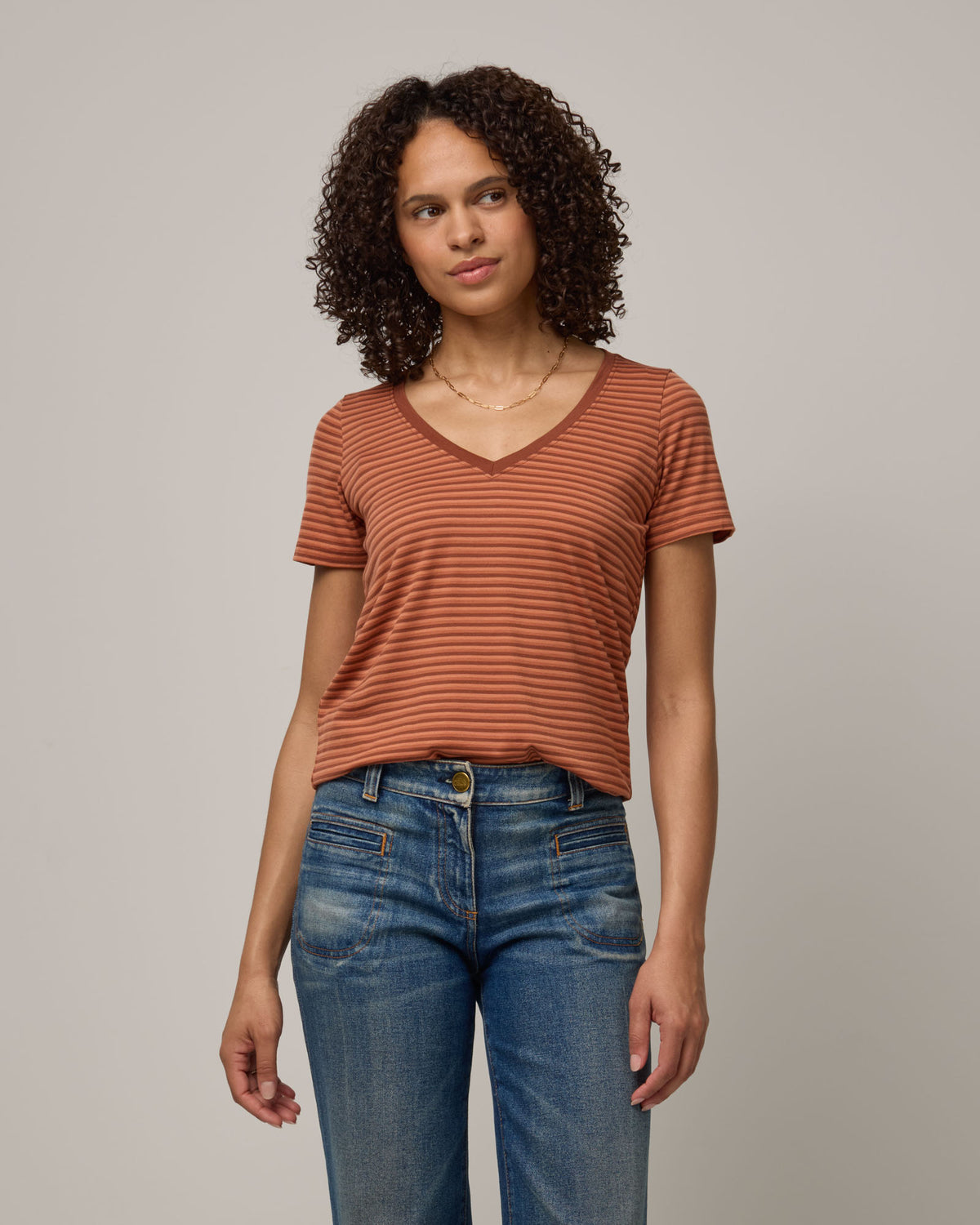 Model wearing Morgan V-Neck Tee in Tonal Cinnamon Stripe. Morgan V-Neck Tee is a merino wool short sleeve, v-neck, regular fit tee available in sizes XS-3X.