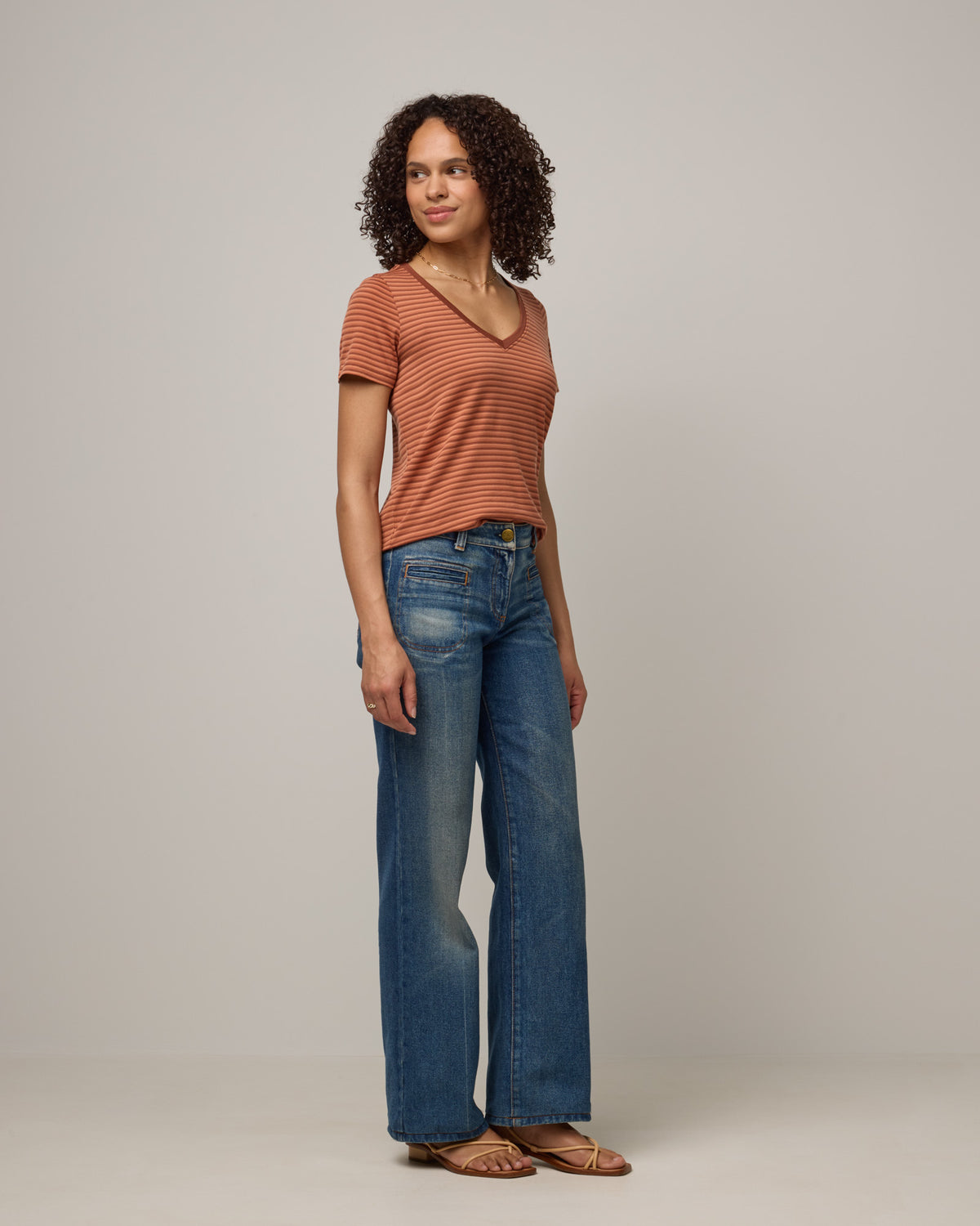 Model wearing Morgan V-Neck Tee in Tonal Cinnamon Stripe. Morgan V-Neck Tee is a merino wool short sleeve, v-neck, regular fit tee available in sizes XS-3X.