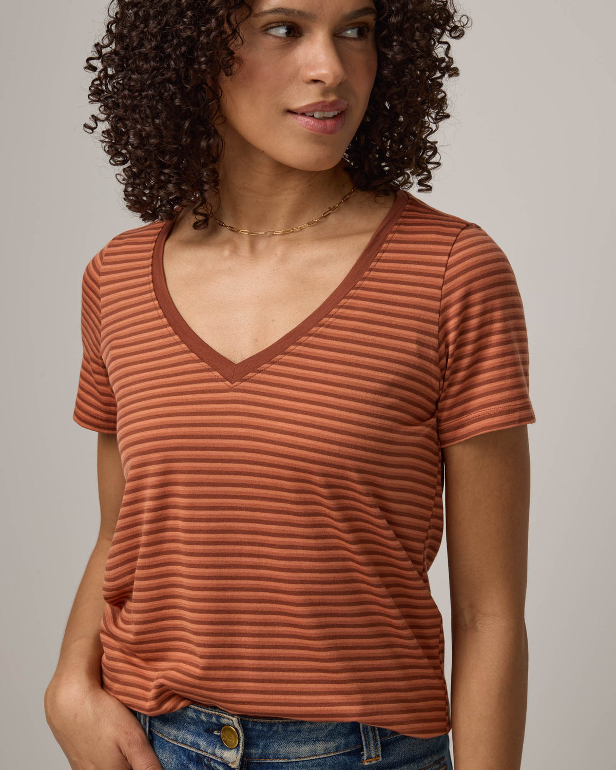 Model wearing Morgan V-Neck Tee in Tonal Cinnamon Stripe. Morgan V-Neck Tee is a merino wool short sleeve, v-neck, regular fit tee available in sizes XS-3X.