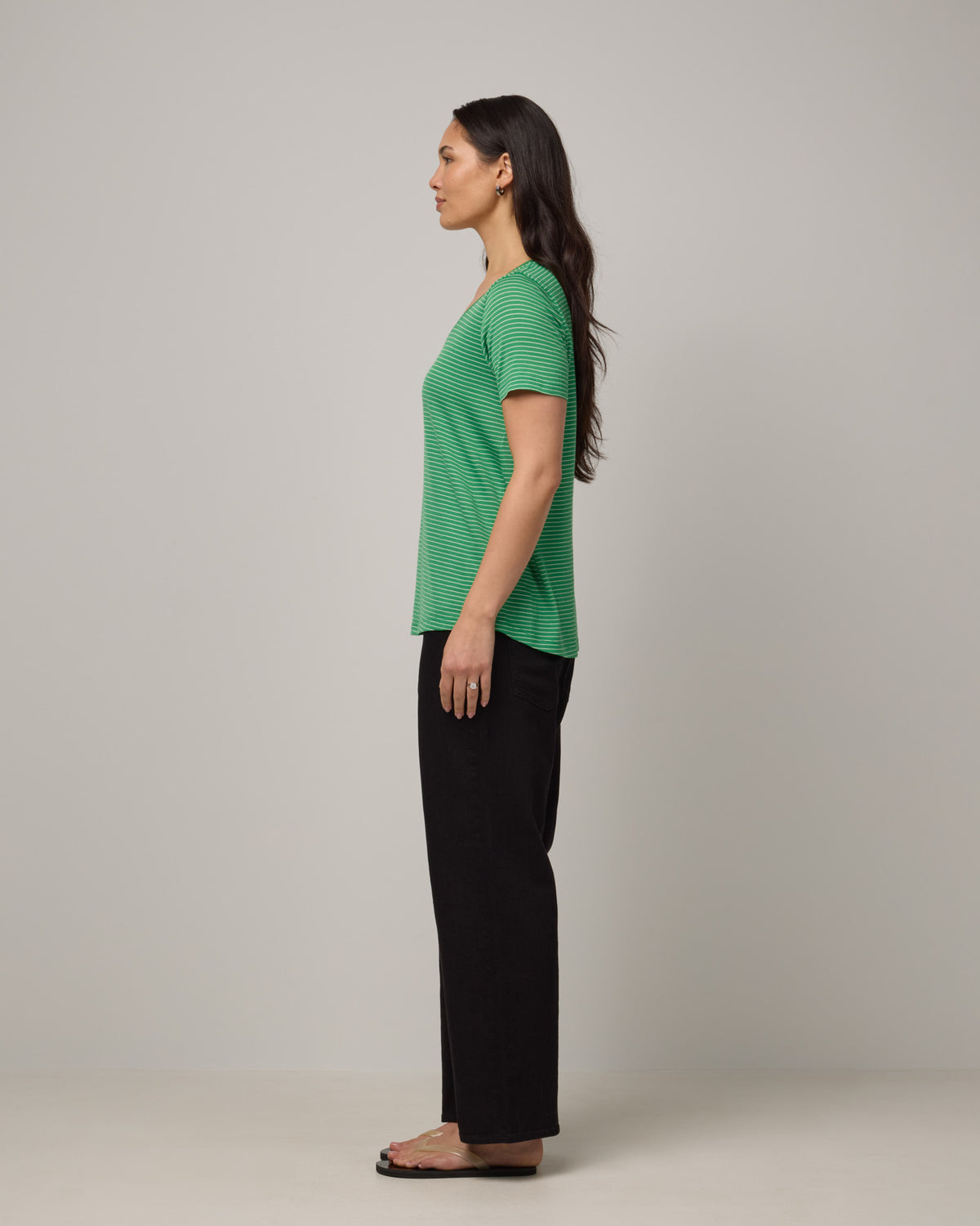 Model wearing Stella Scoop Neck Tee in Verde & Natural White Stripe. Stella Scoop Neck Tee is a merino wool short sleeve, scoop neck t-shirt available in sizes XS-3X.