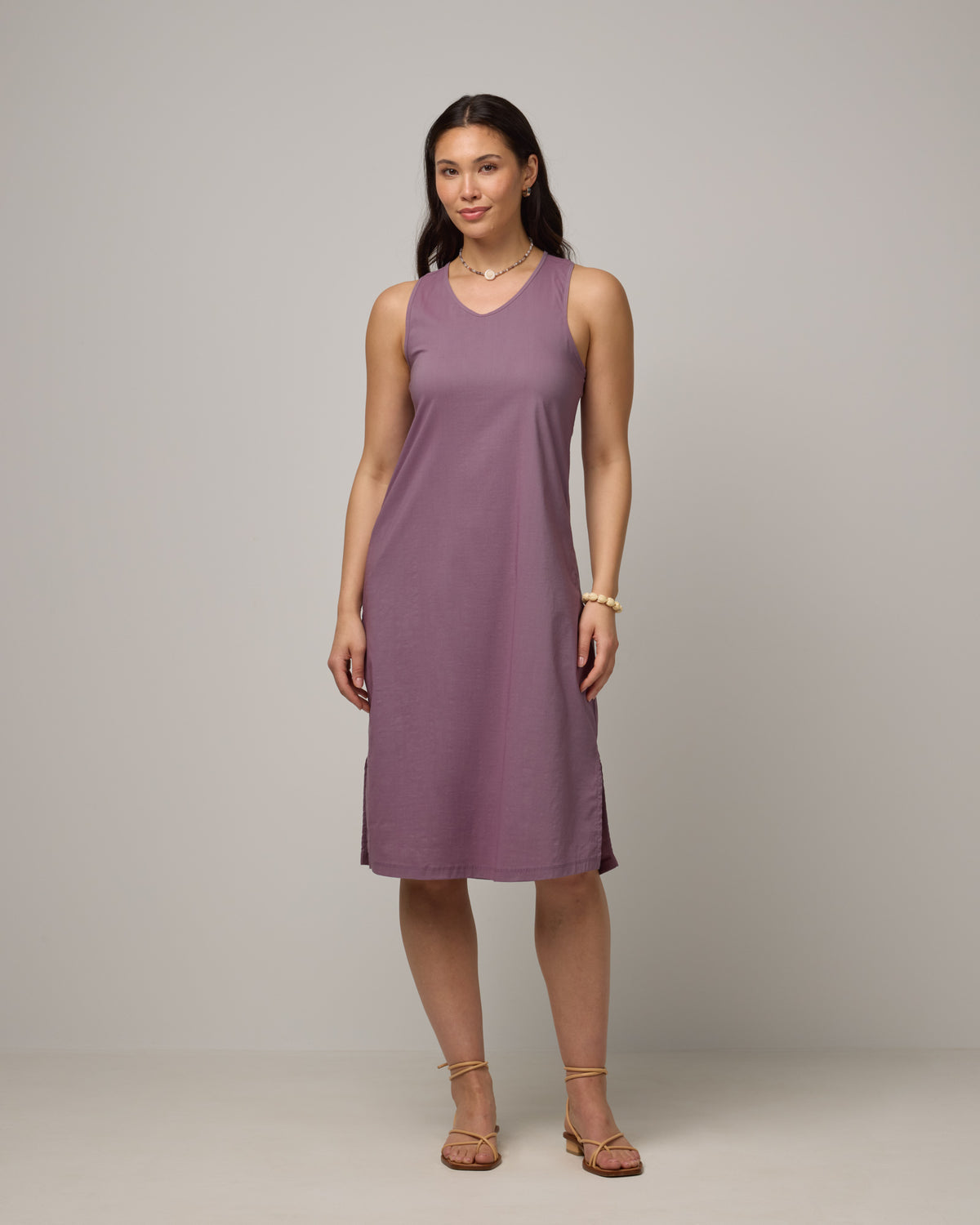 Model wearing Acadia Racerback Dress in Lavender. Acadia Racerback Dress is a merino wool sleeveless, v-neck, midi length fitted dress available in sizes XS-XXL.