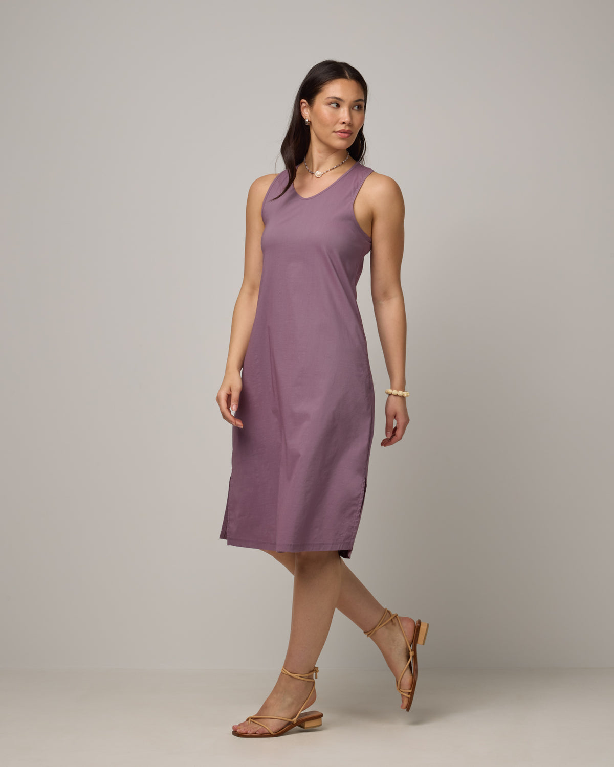 Model wearing Acadia Racerback Dress in Lavender. Acadia Racerback Dress is a merino wool sleeveless, v-neck, midi length fitted dress available in sizes XS-XXL.