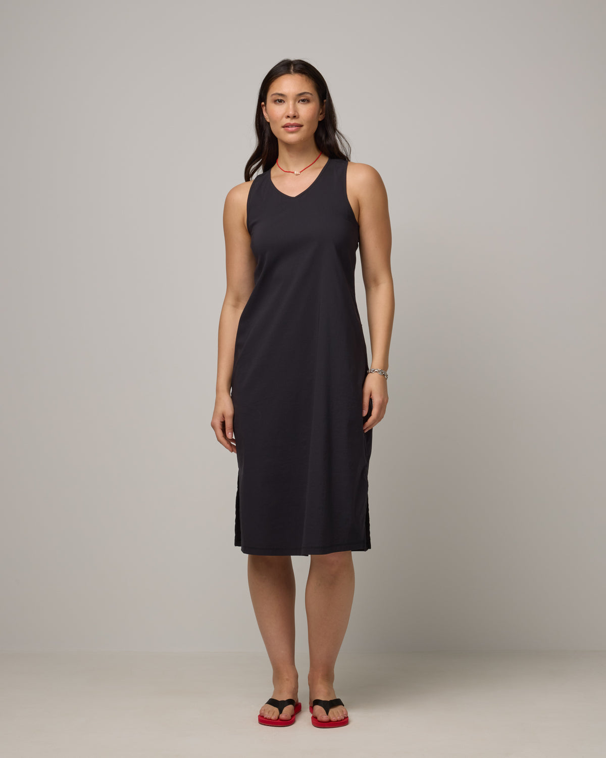 Model wearing Acadia Racerback Dress in Black. Acadia Racerback Dress is a merino wool sleeveless, v-neck, midi length fitted dress available in sizes XS-XXL.