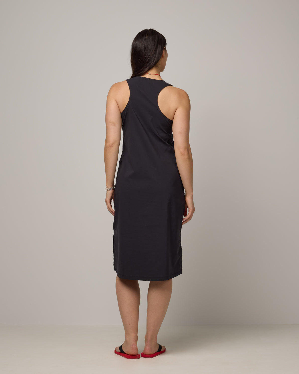 Model wearing Acadia Racerback Dress in Black. Acadia Racerback Dress is a merino wool sleeveless, v-neck, midi length fitted dress available in sizes XS-XXL.