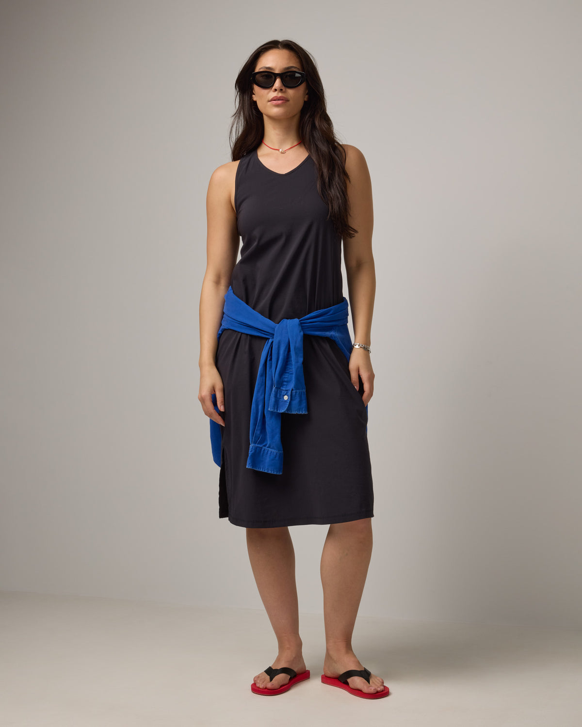 Model wearing Acadia Racerback Dress in Black. Acadia Racerback Dress is a merino wool sleeveless, v-neck, midi length fitted dress available in sizes XS-XXL.