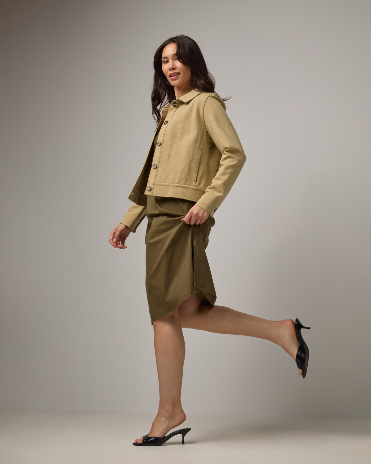 Model wearing Acadia Racerback Dress in Olive. Acadia Racerback Dress is a merino wool sleeveless, v-neck, midi length fitted dress available in sizes XS-XXL.
