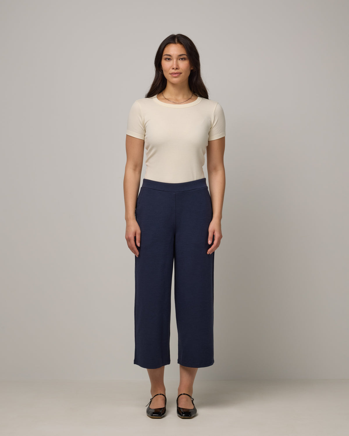 Model wearing Frame Ponte Culotte in Washed Navy. Frame Ponte Culotte is a merino wool pant with pockets available in sizes XS-3X Regular, XS-XL Petite.