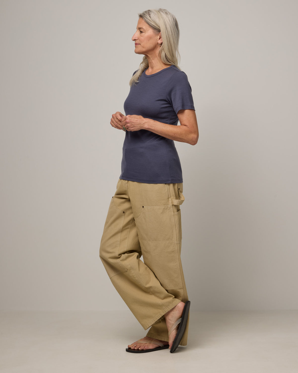 Model wearing Cara 100% Wool Fitted Tee in Odyssey Gray, a slate blue-gray color. Cara 100% Wool Fitted Tee is a merino wool short sleeve, crew neck, slim fit tee available in sizes XS-3X.