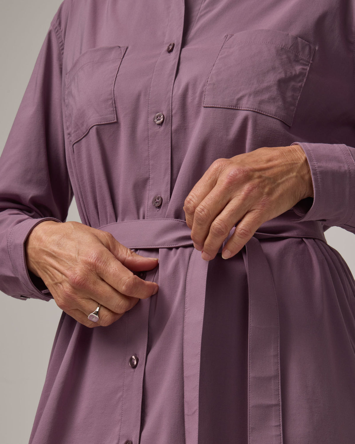 Model wearing Victoria Shirt Dress in Lavender. Victoria Shirt Dress is a merino wool long sleeve, midi length, button-front dress with pockets and removable belt available in sizes XS-XXL.