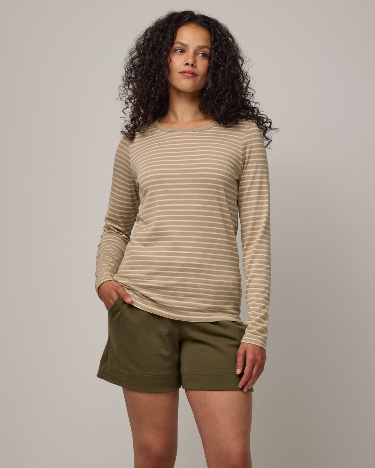 Model wearing Sloan Signature Fitted Tee in Khaki & Natural White Stripe. Sloan Signature Fitted Tee is a merino wool long sleeve, crew neck, slim fit tee available in sizes XS-3X.