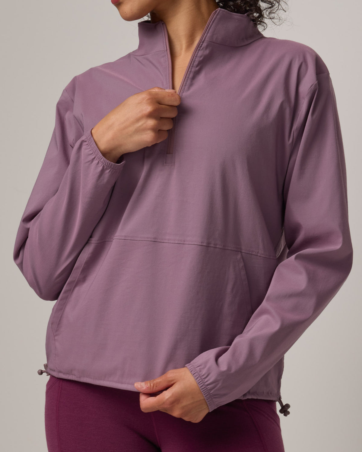 Model wearing Venus Quarter Zip in Lavender. Venus Quarter Zip is a merino wool lightweight long sleeve pullover with a front pocket available in sizes XS-XXL.