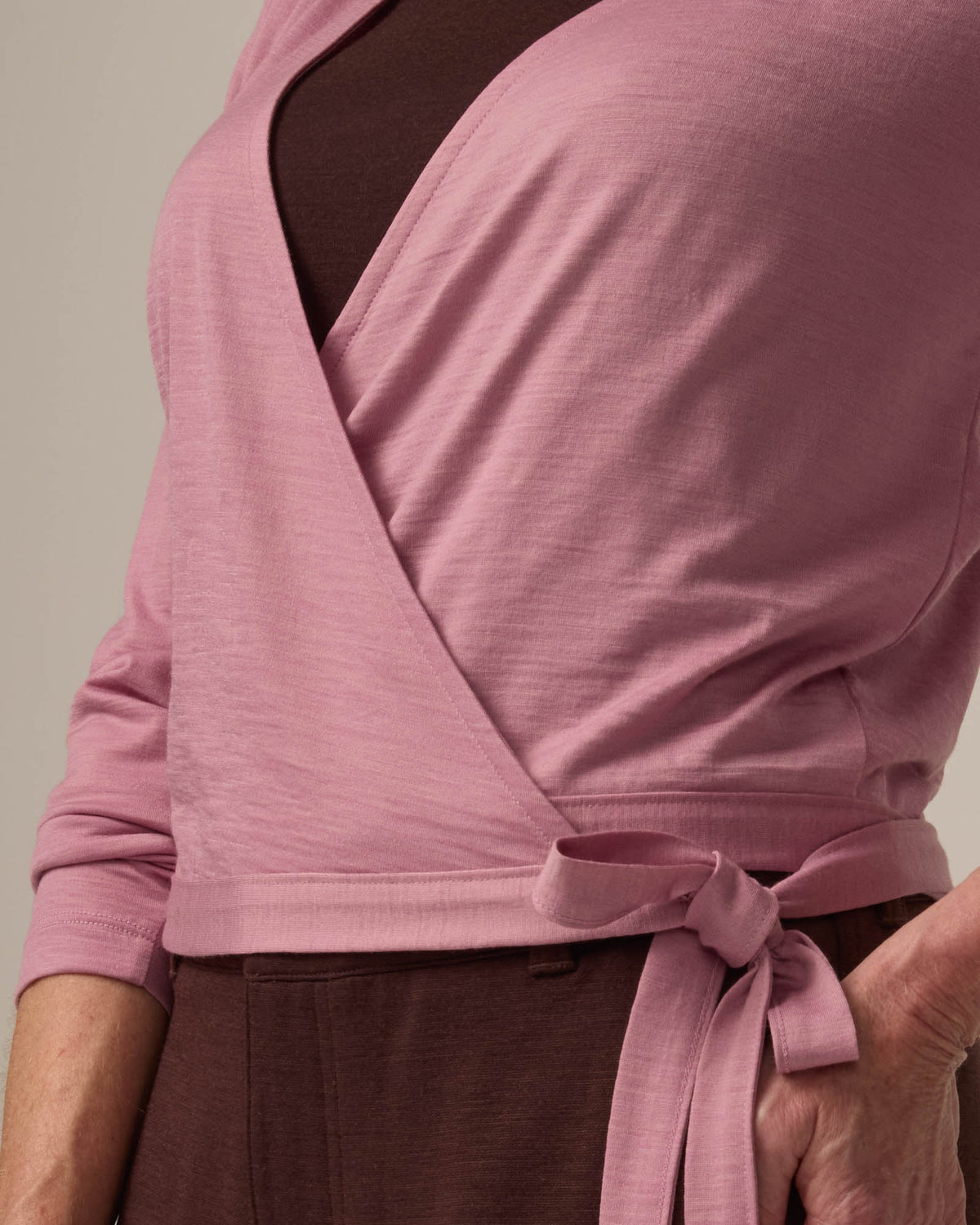 Detail of Natalia Wrap Top in Ballet Pink, a muted light pink color. Natalia Wrap Top is a merino wool long sleeve, v-neck, slim fit top available in sizes XS-3X.