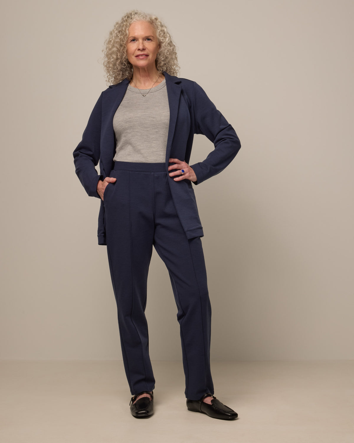 Model wearing Rosso Straight Ponte Pant in Washed Navy. Rosso Straight Ponte Pant is a merino wool pant with pockets available in sizes XS-3X Regular, S-XXL Long.