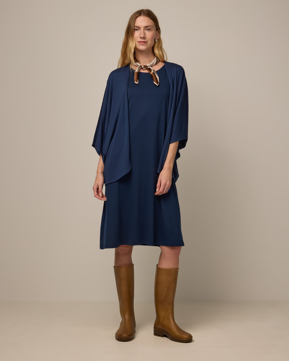 Model wearing Camellia Tank Dress in Marine Blue, a deep royal blue color. Camellia Tank Dress is a merino wool sleeveless, crew neck, knee length swing dress with pockets available in sizes XS-3X Regular, XS-3X Long.