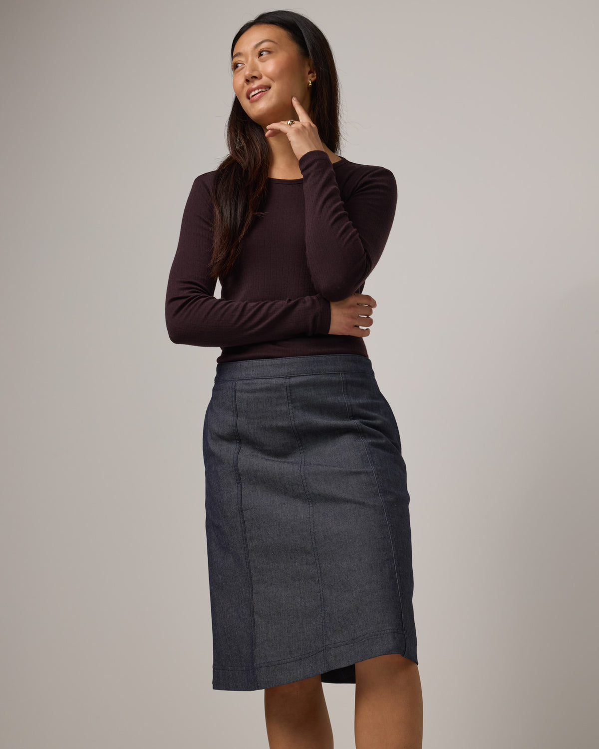 Model wearing Joy Denim Panel Skirt in Indigo Blue. Joy Denim Panel Skirt is a merino wool knee-length skirt available in sizes XS-XXL.