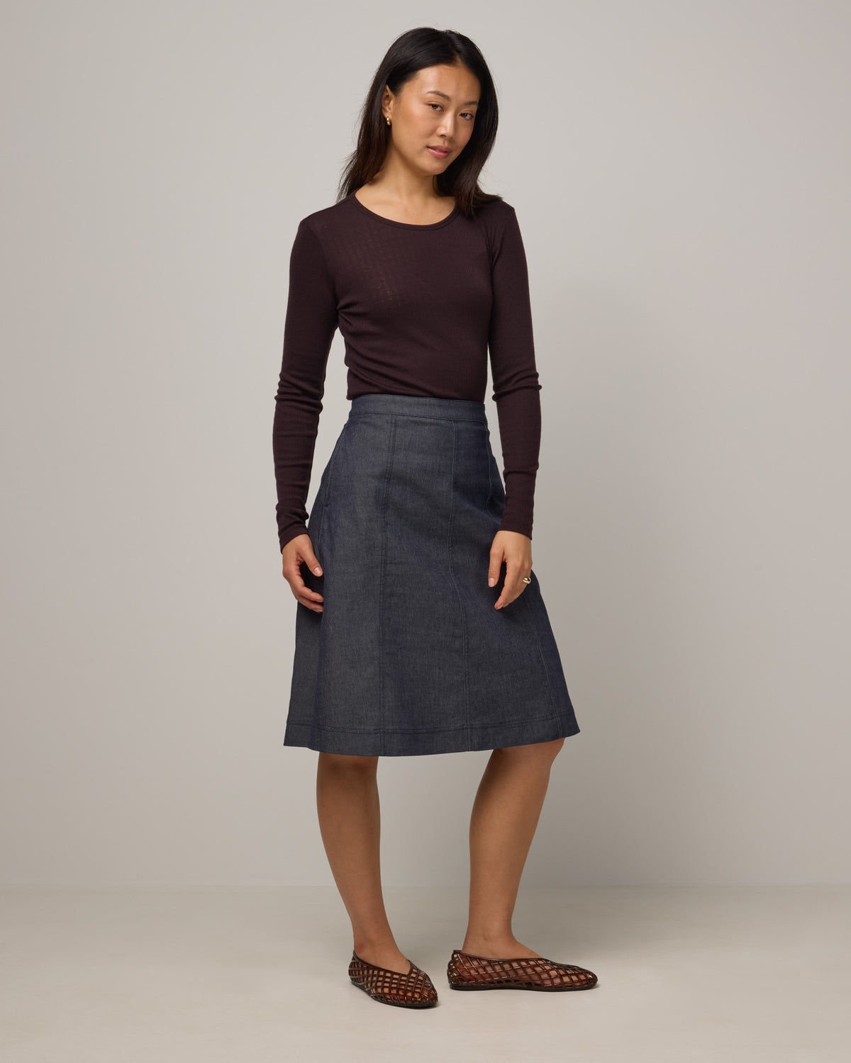 Model wearing Sloan Pointelle Fitted Tee in Espresso, a dark brown color. Sloan Pointelle Fitted Tee is a merino wool long sleeve, crew neck, slim fit tee available in sizes XS-3X.