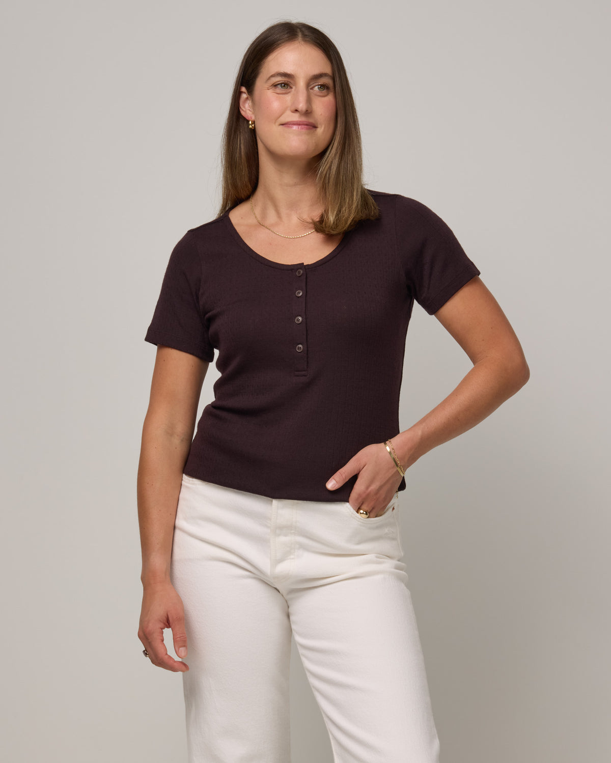 Model wearing Marie Pointelle Henley in Espresso, a dark brown color. Marie Pointelle Henley is a short sleeve, scoop neck, fitted top available in sizes XS-3X. 