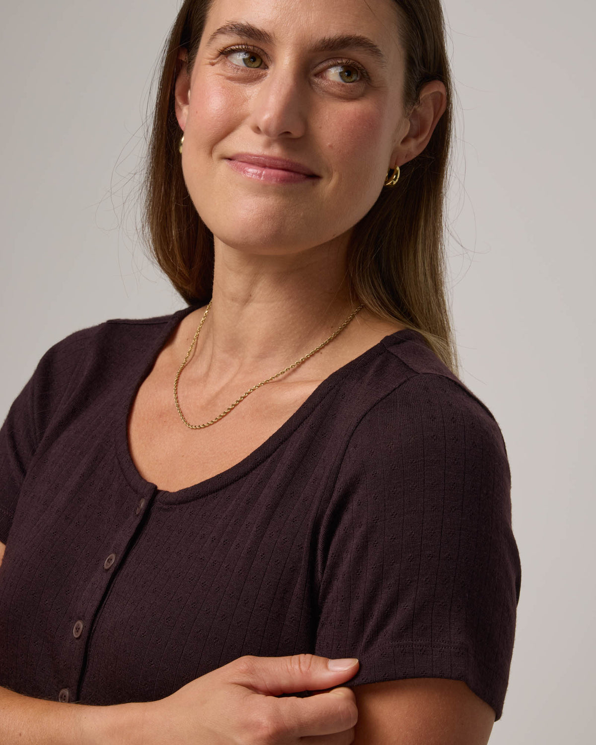 Model wearing Marie Pointelle Henley in Espresso, a dark brown color. Marie Pointelle Henley is a short sleeve, scoop neck, fitted top available in sizes XS-3X. 
