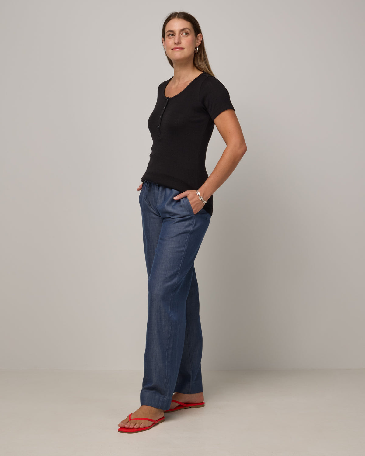 Model wearing Marie Pointelle Henley in Black. Marie Pointelle Henley is a short sleeve, scoop neck, fitted top available in sizes XS-3X. 