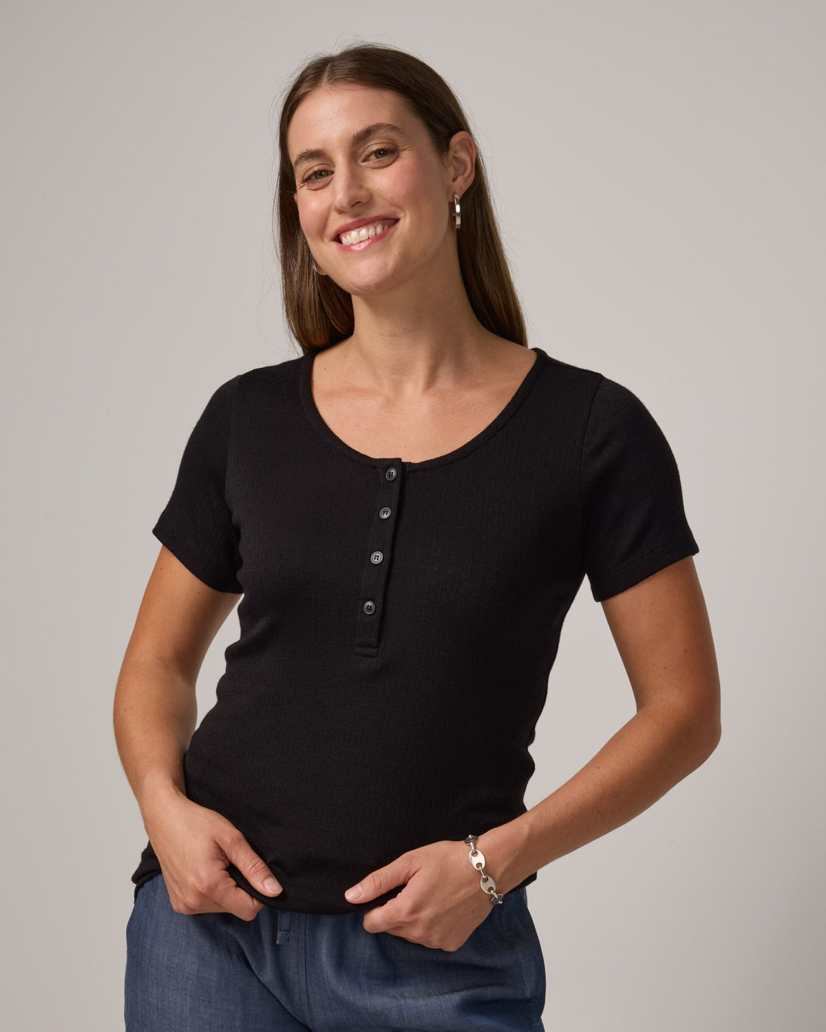 Model wearing Marie Pointelle Henley in Black. Marie Pointelle Henley is a short sleeve, scoop neck, fitted top available in sizes XS-3X. 