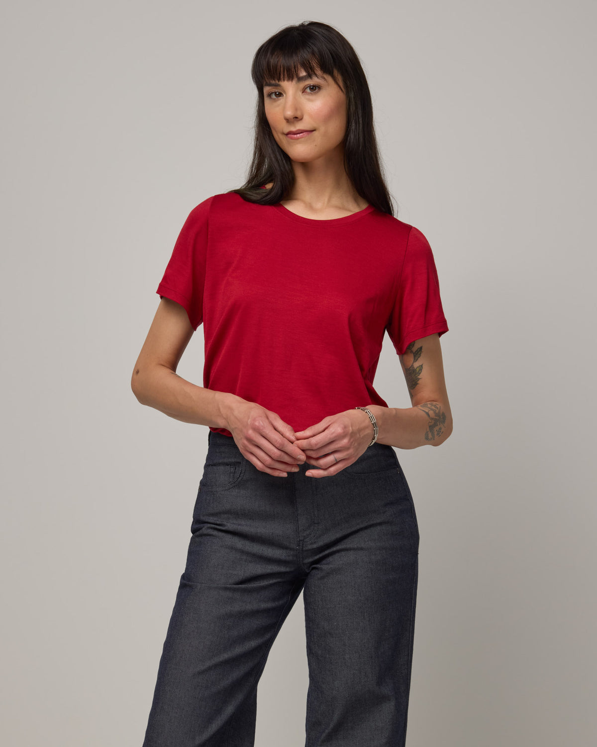 Model wearing Zoe Easy Crew Neck Tee in Cherry Red, a bright red color. Zoe Easy Crew Neck Tee is a merino wool short sleeve, crew neck, regular fit tee available in sizes XS-3X.