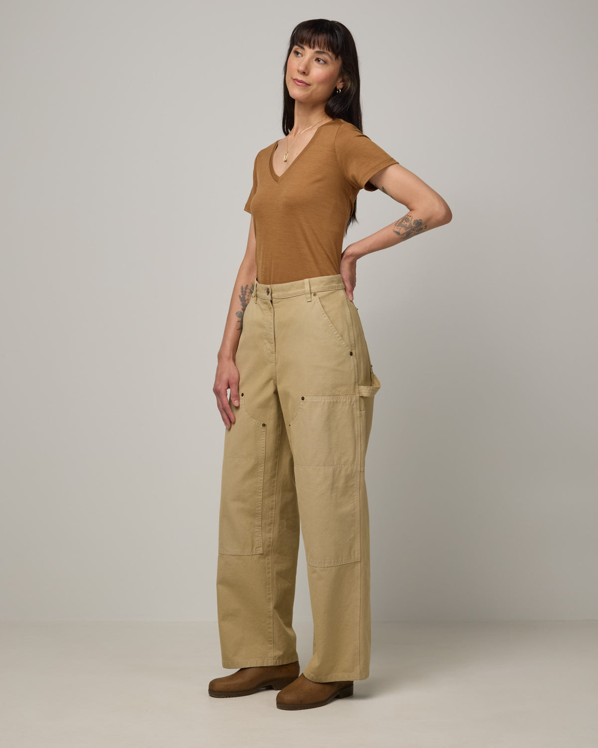 Model wearing Morgan V-Neck Tee in Camel, a caramel brown color. Morgan V-Neck Tee is a merino wool short sleeve, v-neck, regular fit tee available in sizes XS-3X.