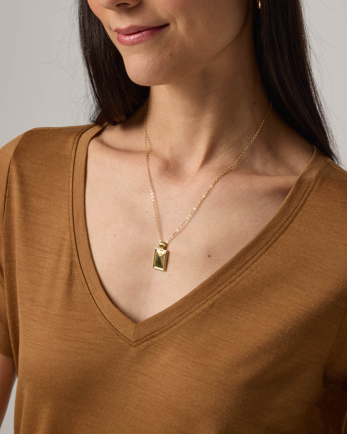 Model wearing Morgan V-Neck Tee in Camel, a caramel brown color. Morgan V-Neck Tee is a merino wool short sleeve, v-neck, regular fit tee available in sizes XS-3X.