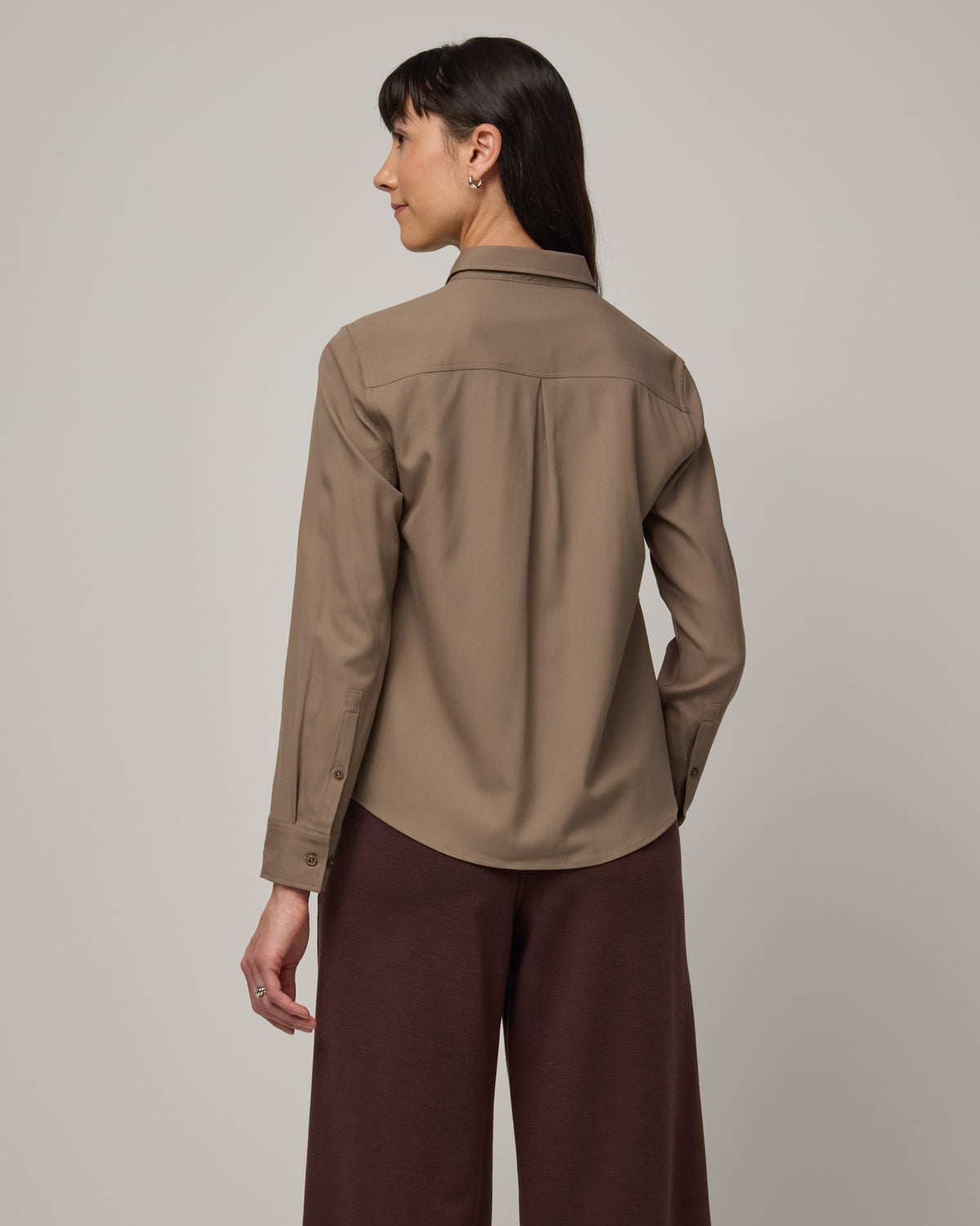 Model wearing Tiffany Button-Front Shirt in Walnut, a taupe brown color. Tiffany Button-Front Shirt is a merino wool long sleeve collared shirt available in sizes XS-XXL.