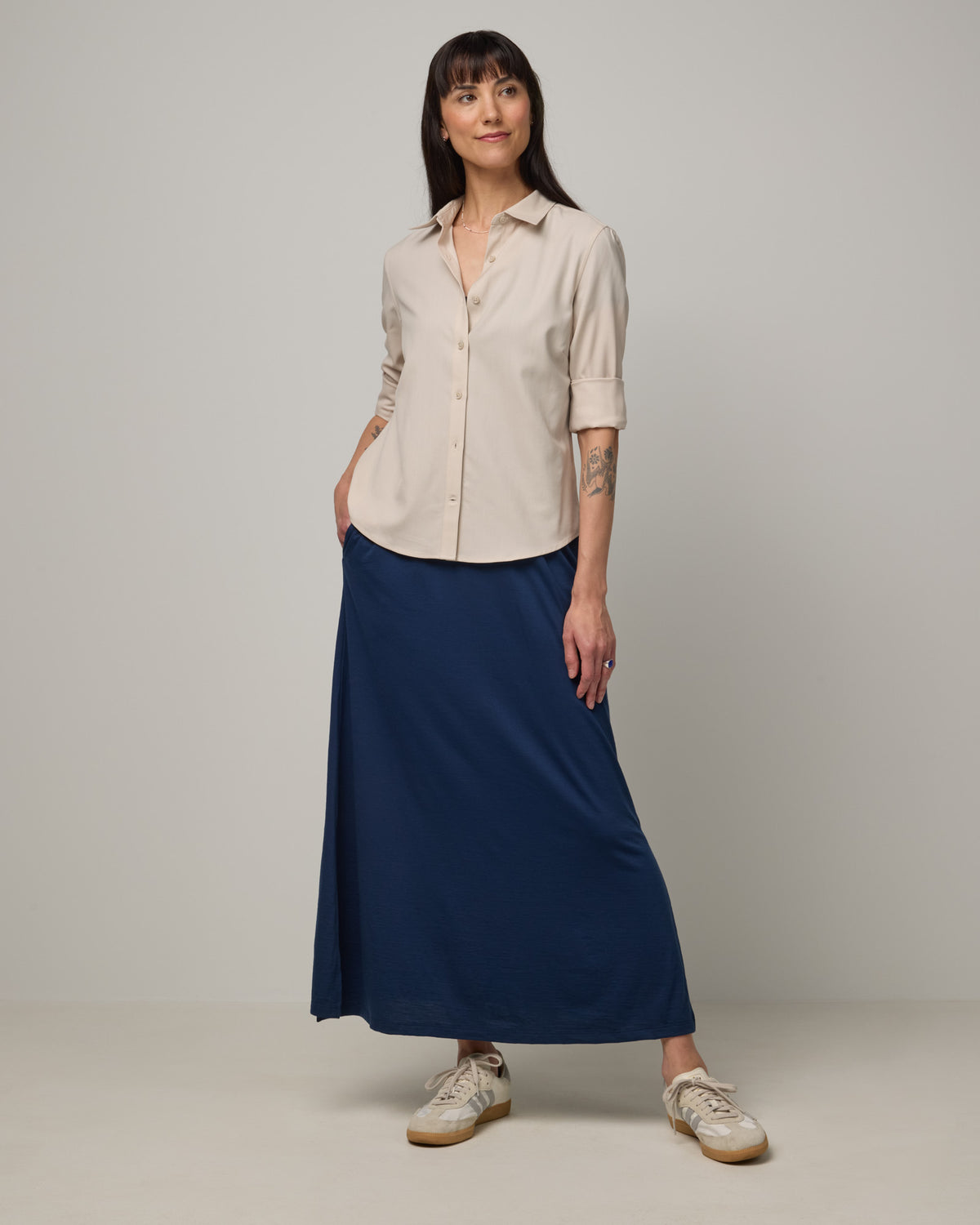 Model wearing Tiffany Button-Front Shirt in Oatmeal, a soft cream color. Tiffany Button-Front Shirt is a merino wool long sleeve collared shirt available in sizes XS-XXL.