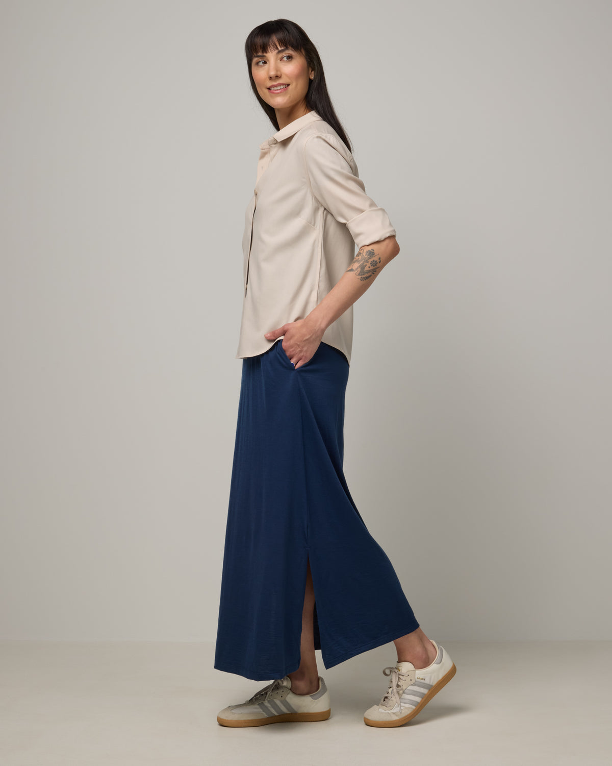 Model wearing Tiffany Button-Front Shirt in Oatmeal, a soft cream color. Tiffany Button-Front Shirt is a merino wool long sleeve collared shirt available in sizes XS-XXL.