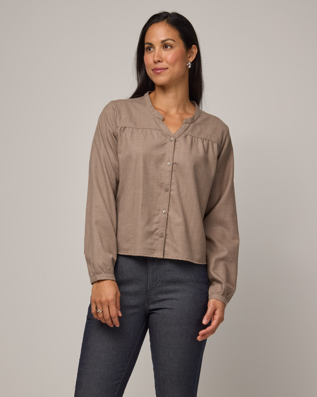 Model wearing Raquel Brushed Twill Top in Taupe Heather, a tan heathered color. Raquel Brushed Twill Top is a 100% merino wool long sleeve, split collar button-front shirt available in sizes XS-XXL.