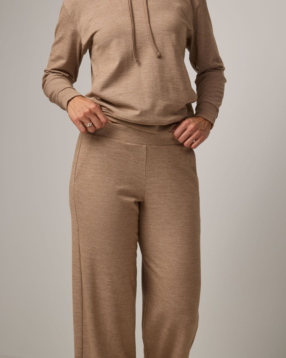Model wearing Aspen Wide Leg Sweatpants in Camel Heather, a warm taupe heather color. Aspen Wide Leg Sweatpant is a merino wool, elastic waist pant available in sizes XS-3X. 