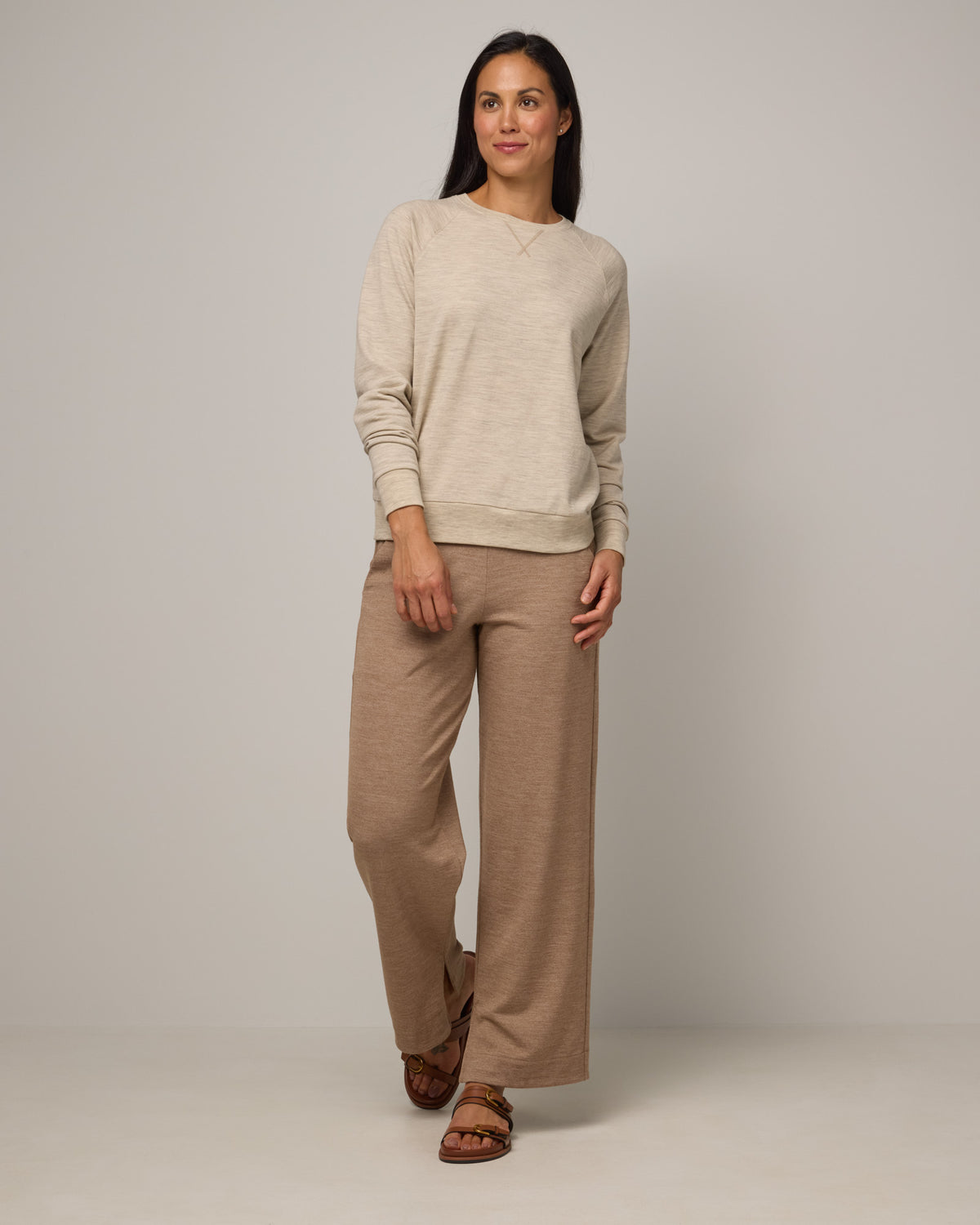 Model wearing Aspen Sweatshirt in Oatmeal Heather, a cream heather color. Aspen Sweatshirt is a merino wool long sleeve, crew neck, regular fit sweatshirt available in sizes XS-3X.