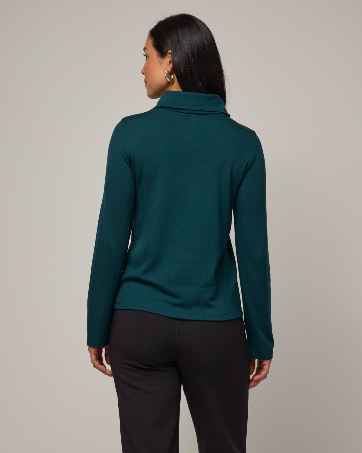 Model wearing Rylie Heavyweight Turtleneck Top in Pine, a dark green color. Rylie Heavyweight Turtleneck Top is a merino wool long sleeve, relaxed fit turtleneck available in sizes XS-3X.